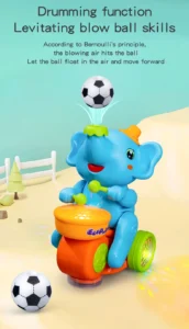 Süßes blaues Baby-Elefanten Spielzeug trommelt auf orangefarbener Trommel mit grünen Schlägeln, lässt Fußball auf dem Rüssel schweben durch Luftstrom nach Bernoulli-Prinzip, leuchtende Lichter, pädagogisches musikalisches Spielzeug für Kleinkinder